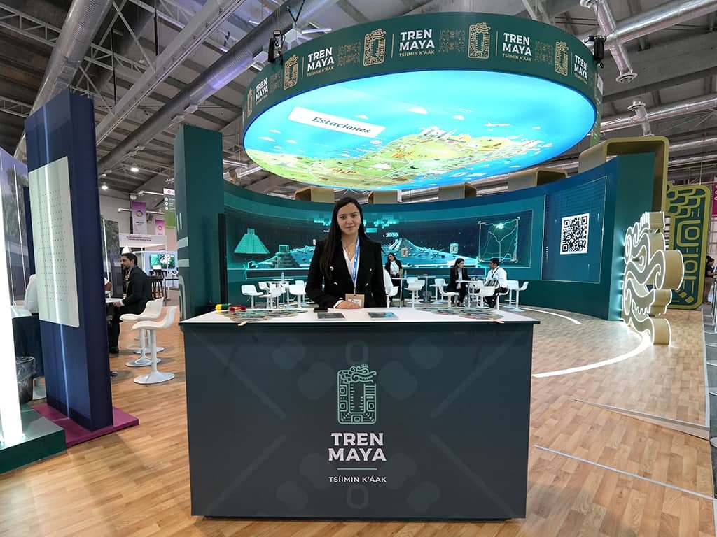 edecan en stand publicitario diseñado a la medida para el tren maya