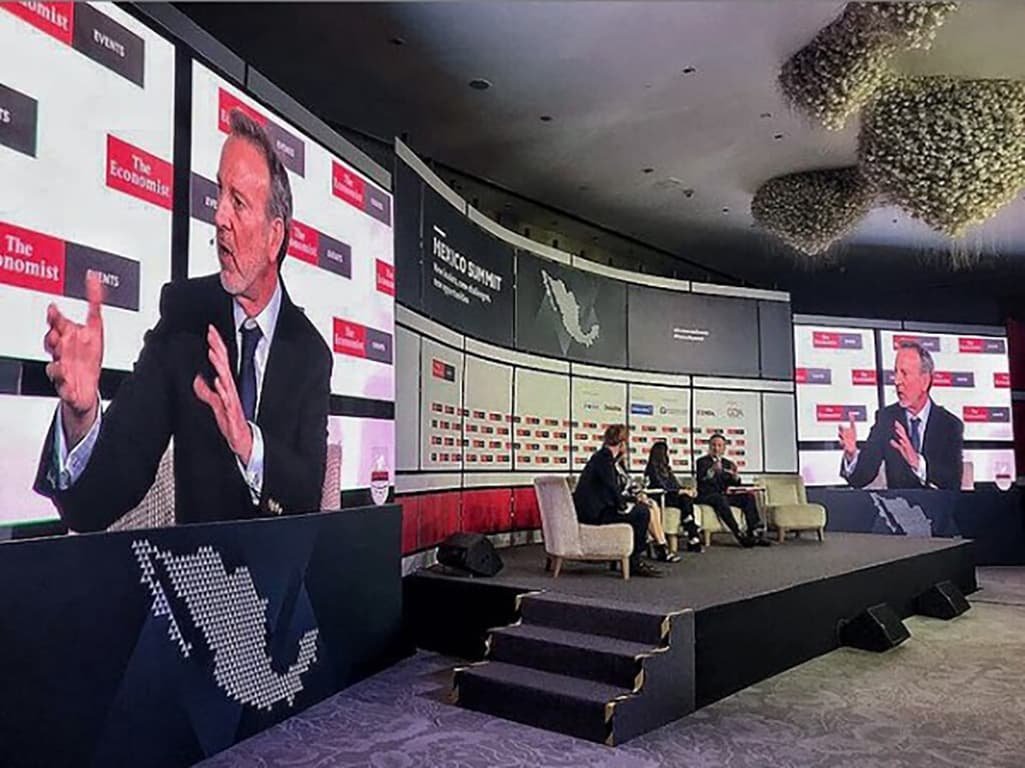 Escenario de summit con pantallas gigantes, background impreso en gran formato sobre tela de 3.20m