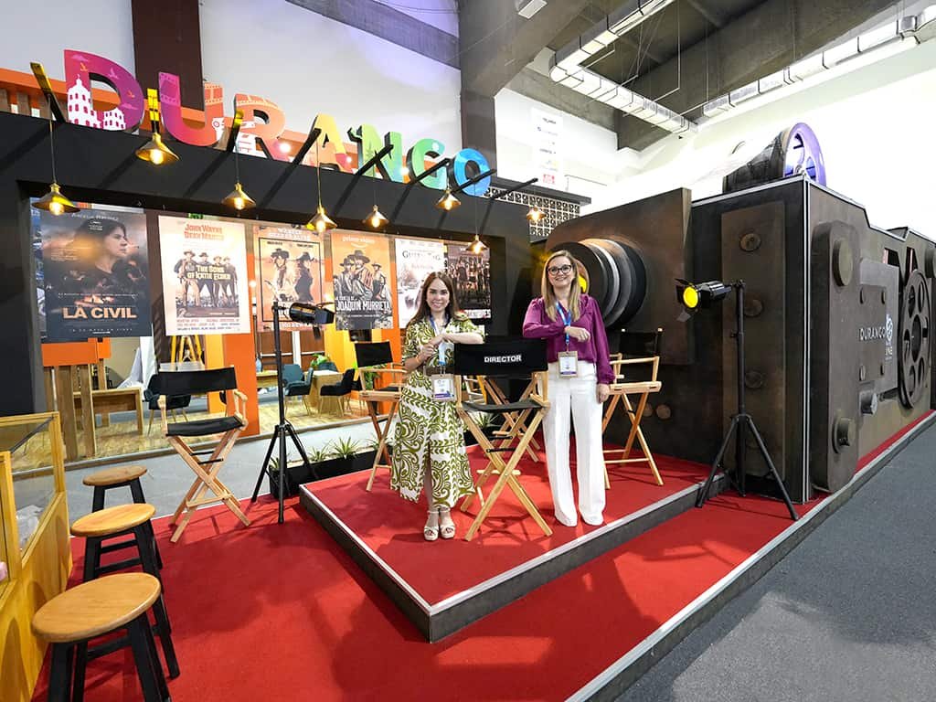 stand publicitario diseñado a la medida para la expo durango con una cámara de cine gigante y dos edecanes